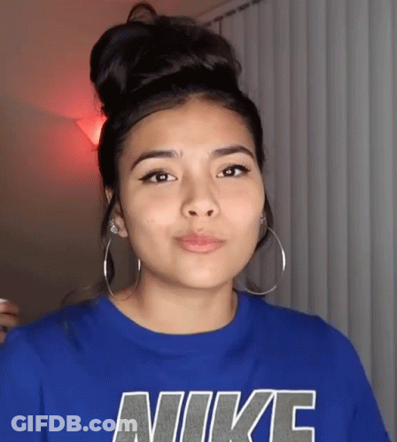 A Woman Wearing A Blue Nike Shirt With Hoop Earrings GIF