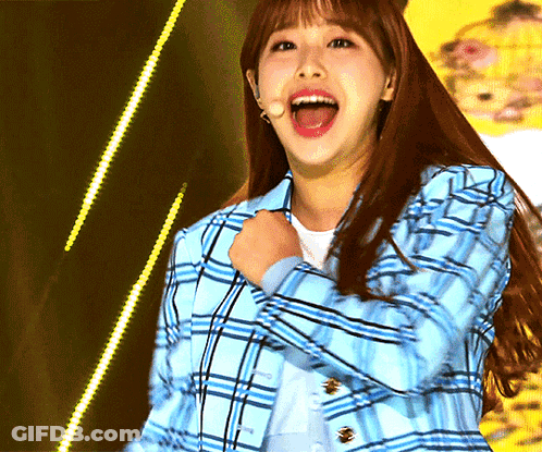 A Woman Wearing A Blue Plaid Jacket Is Laughing With Her Mouth Wide Open GIF