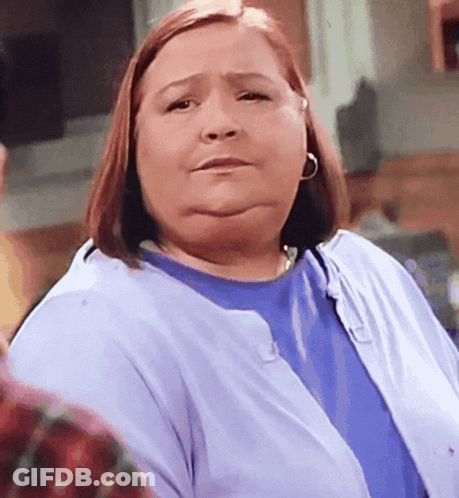 A Woman Wearing A Blue Shirt And A Purple Cardigan GIF