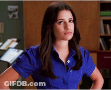 A Woman Wearing A Blue Shirt Is Standing With Her Hands On Her Hips GIF