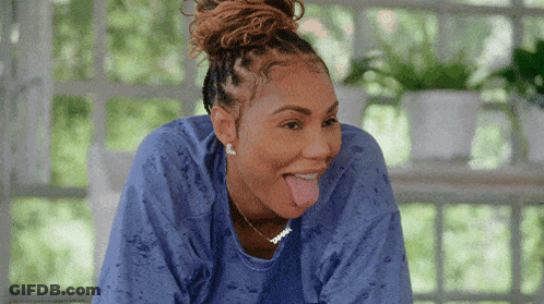 A Woman Wearing A Blue Shirt Is Sticking Out Her Tongue GIF