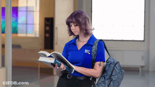 A Woman Wearing A Blue Shirt That Says Best Buy Is Reading A Book GIF