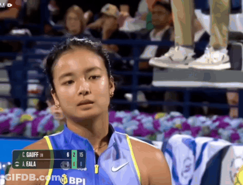 A Woman Wearing A Blue Shirt That Says Bpi On It Looks At The Camera GIF
