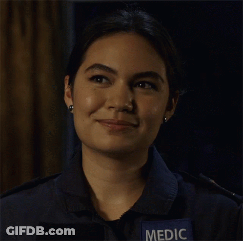 A Woman Wearing A Blue Shirt With A Patch That Says Medic On It GIF