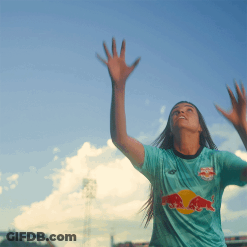 A Woman Wearing A Blue Shirt With A Red Bull On The Front GIF