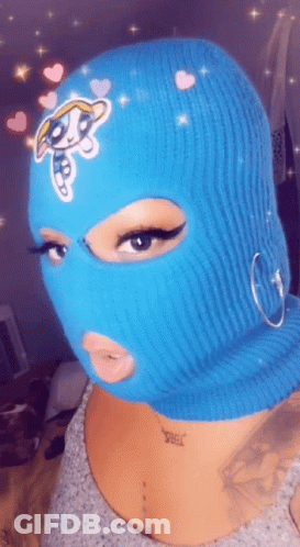 A Woman Wearing A Blue Ski Mask With A Cartoon Character On It . GIF