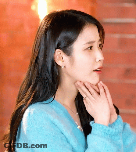 A Woman Wearing A Blue Sweater And A Ring On Her Finger GIF