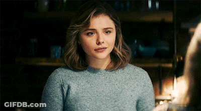 A Woman Wearing A Blue Sweater Looks At The Camera GIF