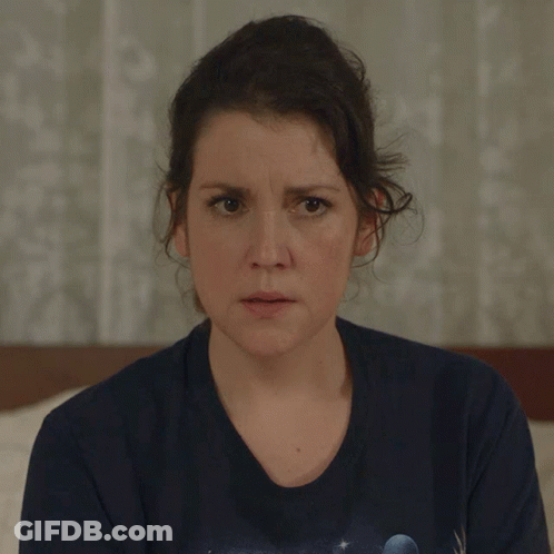 Woman In Blue T-Shirt With Planet Looks At Camera GIF