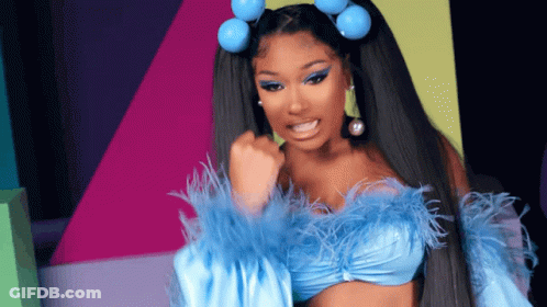 A Woman Wearing A Blue Top With Feathers And Blue Hair Rollers GIF