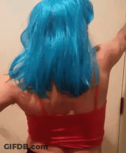 A Woman Wearing A Blue Wig And A Red Tank Top Is Dancing . GIF