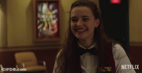 A Woman Wearing A Bow Tie Is Smiling In Front Of A Netflix Logo GIF