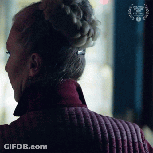 A Woman Wearing A Braided Bun Is Standing In Front Of A Sign That Says Atlanta Short Film Festival GIF