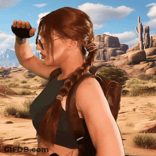 A Woman Wearing A Braided Ponytail And Sunglasses Stands In A Desert GIF