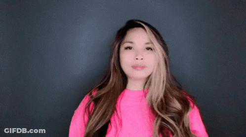 A Woman Wearing A Bright Pink Sweater Is Making A Funny Face GIF