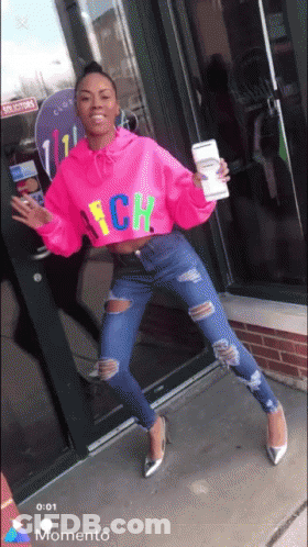A Woman Wearing A Bright Pink Sweater That Says Nch GIF