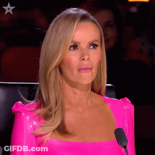 A Woman Wearing A Bright Pink Top Is Sitting In Front Of A Microphone GIF