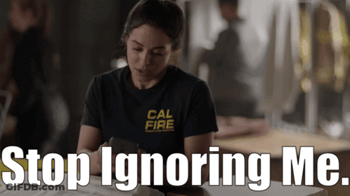 A Woman Wearing A Cal Fire Shirt Sits At A Desk GIF