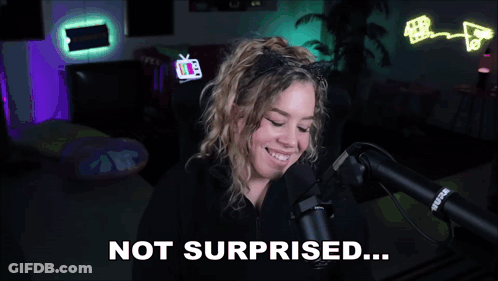 A Woman Wearing A Cat Ear Headband Is Talking Into A Microphone And Says Not Surprised GIF