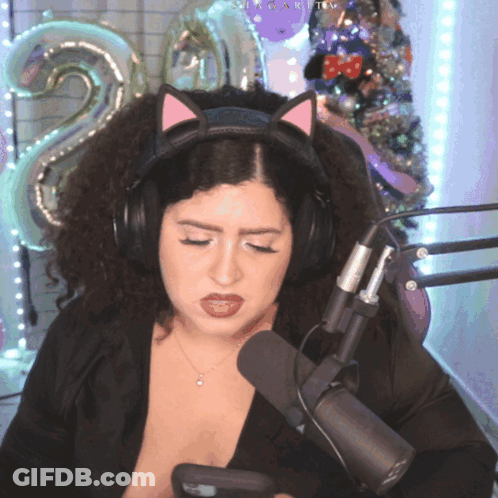 A Woman Wearing A Cat Ear Headband Looks At Her Phone GIF