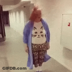 Woman In Cat Sweater Walking Down Hallway GIF