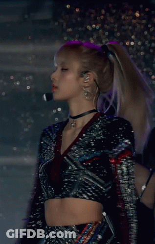 A Woman Wearing A Choker And A Crop Top Is Standing In Front Of A Microphone GIF