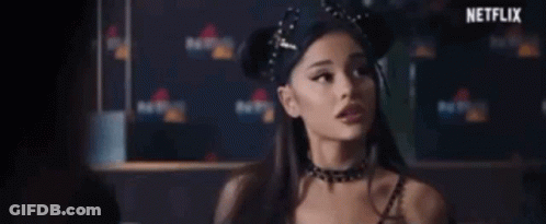 A Woman Wearing A Choker And A Headband Is Standing In Front Of A Netflix Banner . GIF