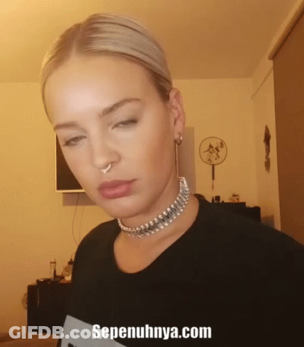A Woman Wearing A Choker And A Nose Ring With The Website Sepenuhnya.com Written Below Her GIF
