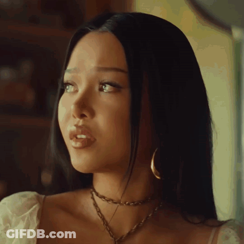 A Woman Wearing A Choker And Hoop Earrings Looks To Her Left GIF