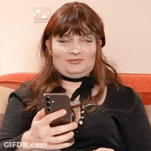 A Woman Wearing A Choker Is Looking At Her Phone GIF