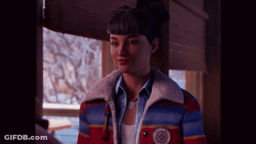 A Woman Wearing A Colorful Jacket And A Necklace With A Snowflake On It GIF