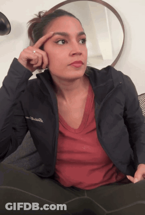 A Woman Wearing A Columbia Jacket Holds Her Finger To Her Eyebrow GIF