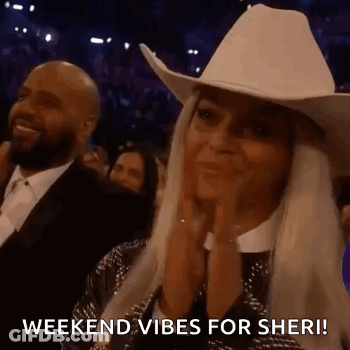 A Woman Wearing A Cowboy Hat Is Clapping Her Hands In A Crowd At A Concert . GIF