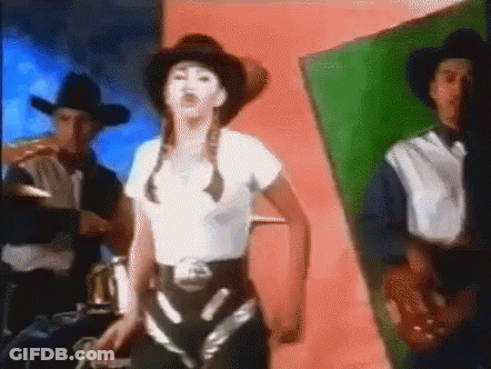 A Woman Wearing A Cowboy Hat Is Dancing With Two Men GIF