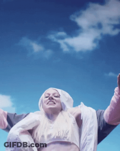A Woman Wearing A Crop Top And A Hooded Jacket With The Word Nike On It GIF