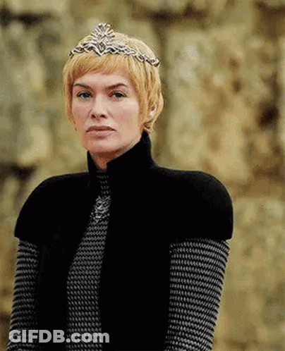 A Woman Wearing A Crown And A Black Vest Is Standing In Front Of A Wall . GIF