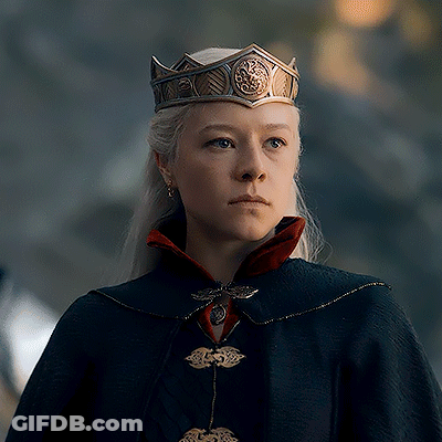 A Woman Wearing A Crown And A Cape Is Looking At The Camera GIF