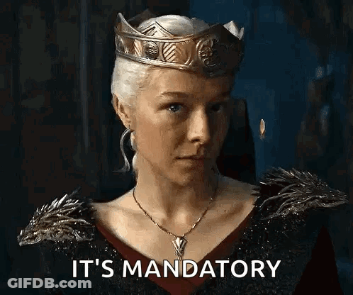 A Woman Wearing A Crown And A Necklace Is Saying `` It 'S Mandatory '' In A Dark Room . GIF