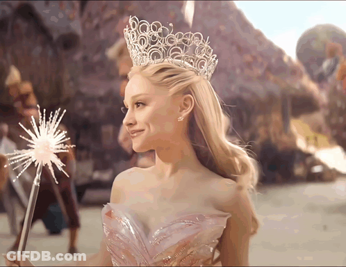 A Woman Wearing A Crown And A Pink Dress Holds A Sparkler GIF