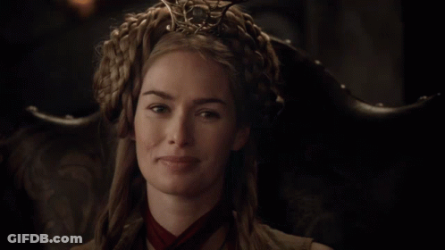 A Woman Wearing A Crown And A Red Scarf Is Smiling GIF