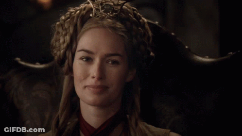 A Woman Wearing A Crown And A Red Scarf Is Smiling GIF