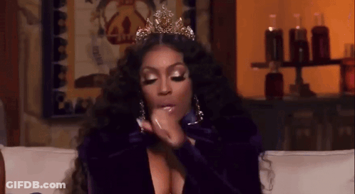 A Woman Wearing A Crown Is Sitting On A Couch Talking On A Cell Phone . GIF