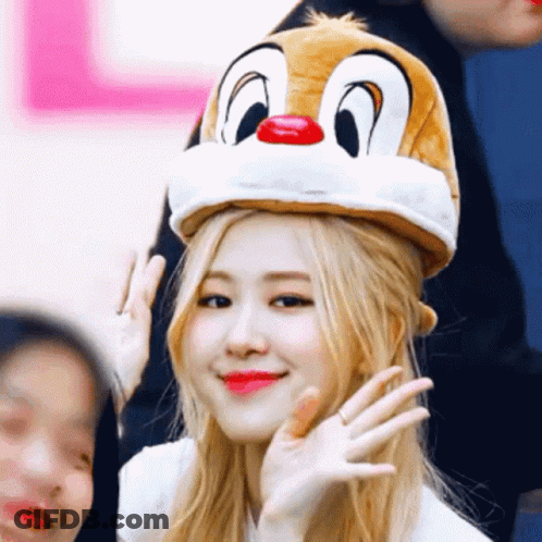 A Woman Wearing A Dale The Squirrel Hat Waves At The Camera GIF