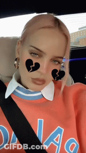 A Woman Wearing A Dallas Sweatshirt Is Sitting In The Back Seat Of A Car GIF