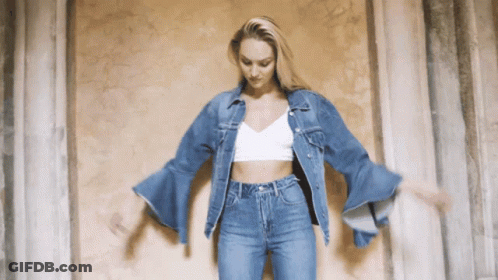 A Woman Wearing A Denim Jacket And Jeans Is Dancing GIF