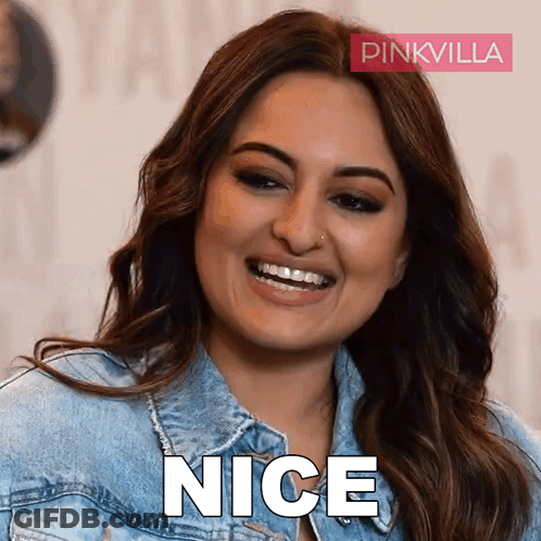 A Woman Wearing A Denim Jacket Is Smiling And The Word Nice Is Visible GIF