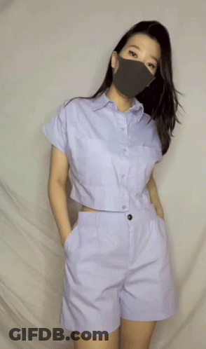 A Woman Wearing A Face Mask And A Crop Top GIF