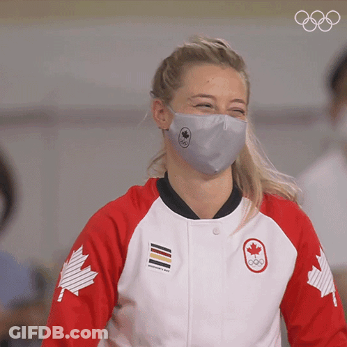 A Woman Wearing A Face Mask And A Jacket With A Canadian Maple Leaf On The Sleeves GIF