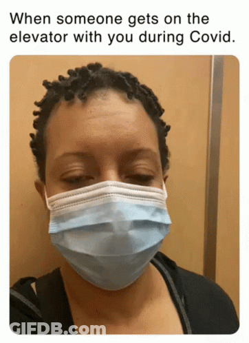 A Woman Wearing A Face Mask In An Elevator GIF