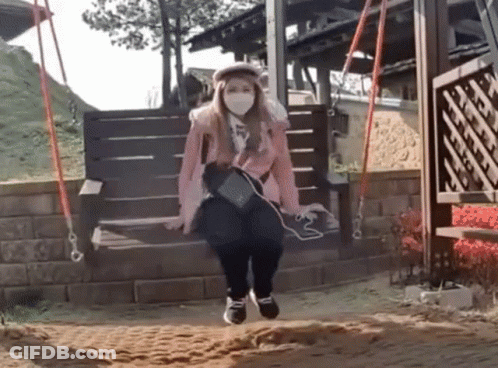 Woman Wearing Face Mask Sitting On Wooden Swing GIF